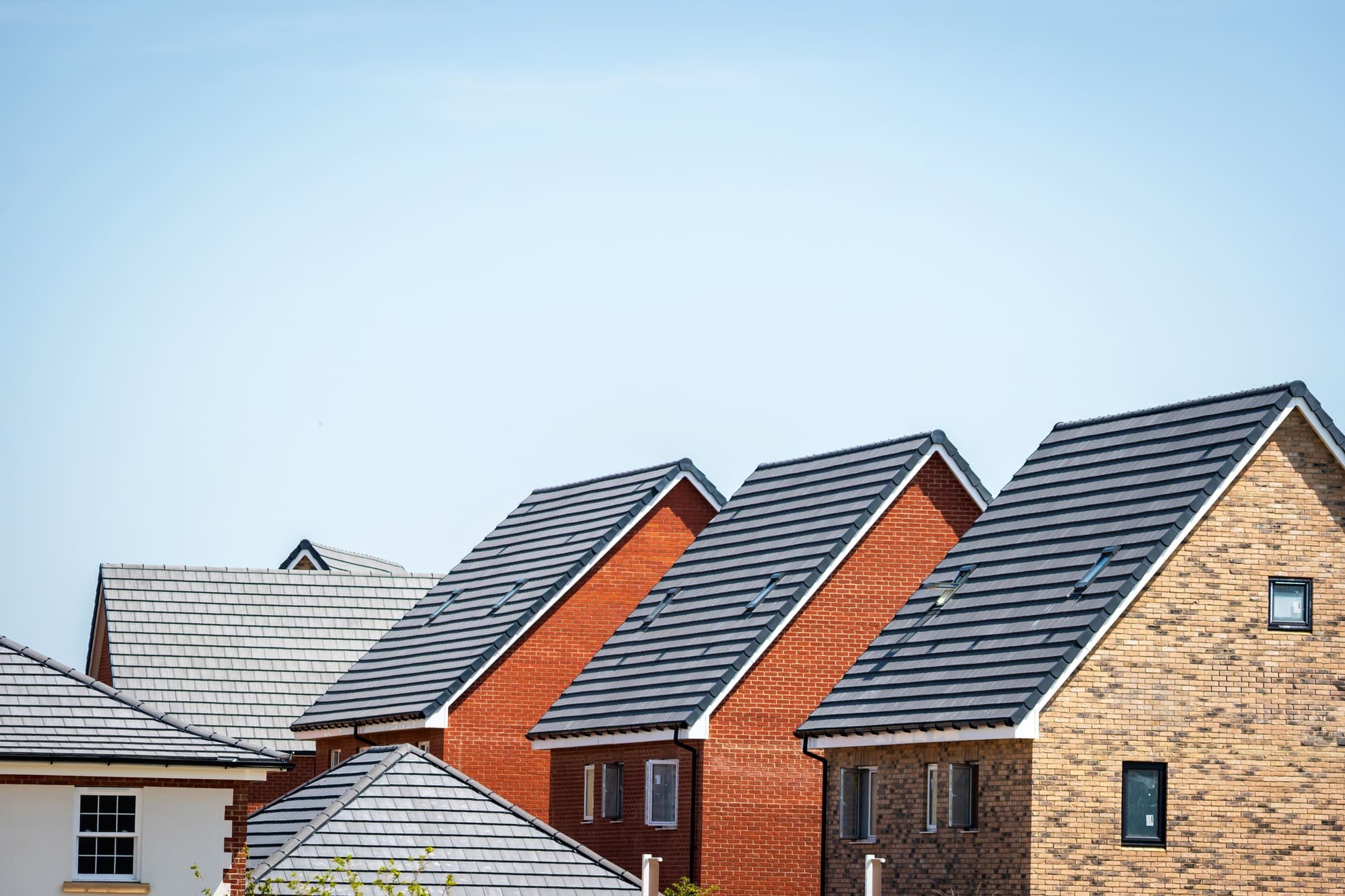 A row of newly built houses under a clear sky