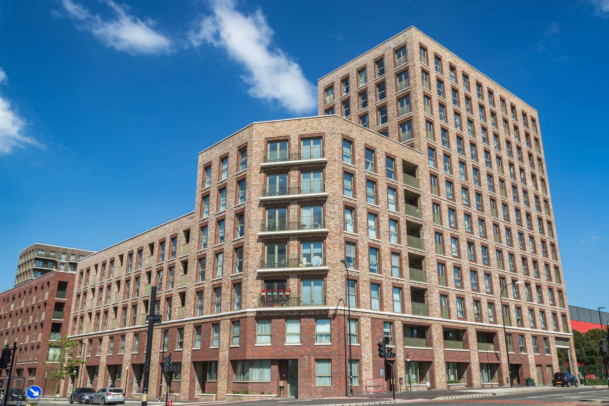 A large brick apartment building against a blue sky